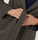 Oversize Blazer zum Wickeln mit Gürtel in Braun mit blauem Karo Muster und Schalkragen. Das blaue Innenfutter kommt schön hervor, wenn man die Ärmel lässig aufkrempelt.  Die großen aufgesetzten Taschen verleihen dem Blazer eine sportive Note. Wir empfehlen die gewohnte Größe 63% Poliester, 32% Viskose, 5% Elasthan