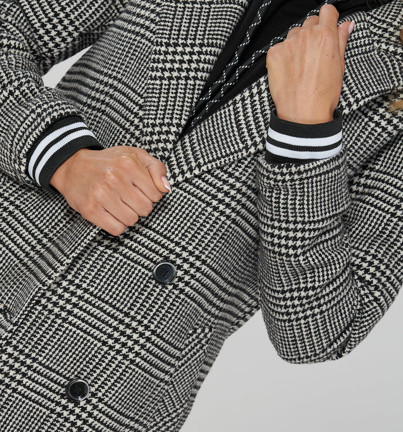 Cooler Zwei-Reiher Mantel in schwarz/weißem Karo Muster. Für den sportiven Look sorgen die College-Bündchen an den Ärmeln, die du problemlos im Inneren verschwinden lassen kannst, wenn du einen eleganteren Look kreieren möchtest.  80% Baumwolle, 20% Poliester Wir empfehlen eine Nummer größer  